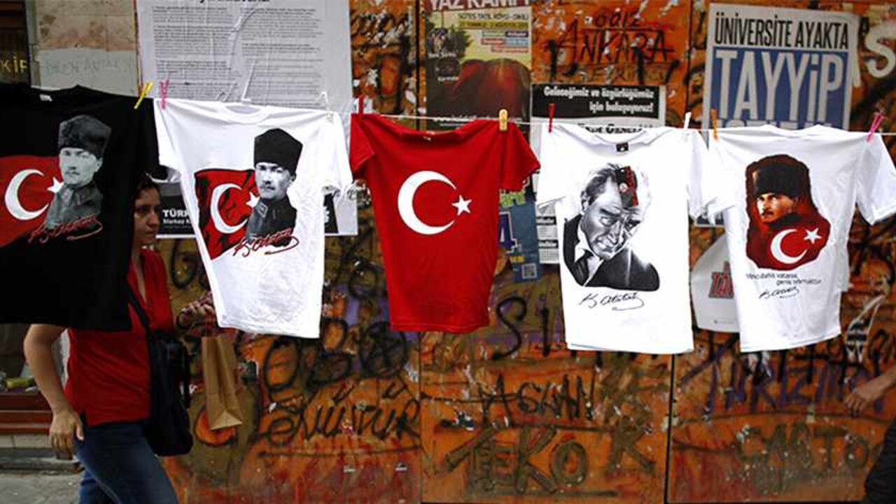 TURKEY-PROTESTS/ People walk by T-shirts with portraits of Mustafa Kemal Ataturk, founder of modern Turkey, displayed for sale near Taksim Square in Istanbul June 8, 2013. Thousands of Turks dug in on Saturday for a weekend of anti-government demonstrations despite Prime Minister Tayyip Erdogan's demand for an immediate end to protests that have spawned the most violent riots of his decade in power. REUTERS/Stoyan Nenov (TURKEY - Tags: POLITICS CIVIL UNREST TPX IMAGES OF THE DAY) - RTX10G76