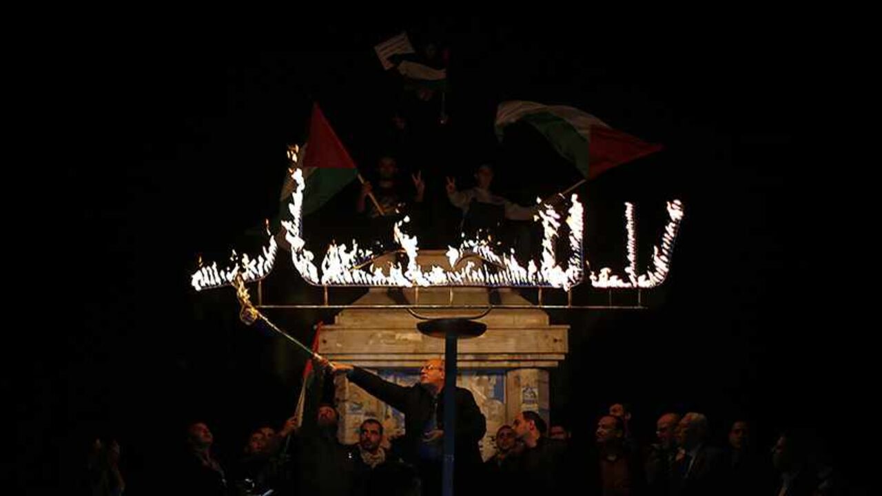 PALESTINIANS-ISRAEL/ A Palestinian uses a torch to light a sign that reads "no to the blockade" during a protest against the blockade on Gaza in Gaza City November 30, 2013. Israel imposed a blockade on Gaza in 2007 after Islamist group Hamas seized control of the territory in a brief civil war with Western-backed Palestinian President Mahmoud Abbas's Fatah party. REUTERS/Suhaib Salem (GAZA - Tags: CIVIL UNREST POLITICS) - RTX15YUD