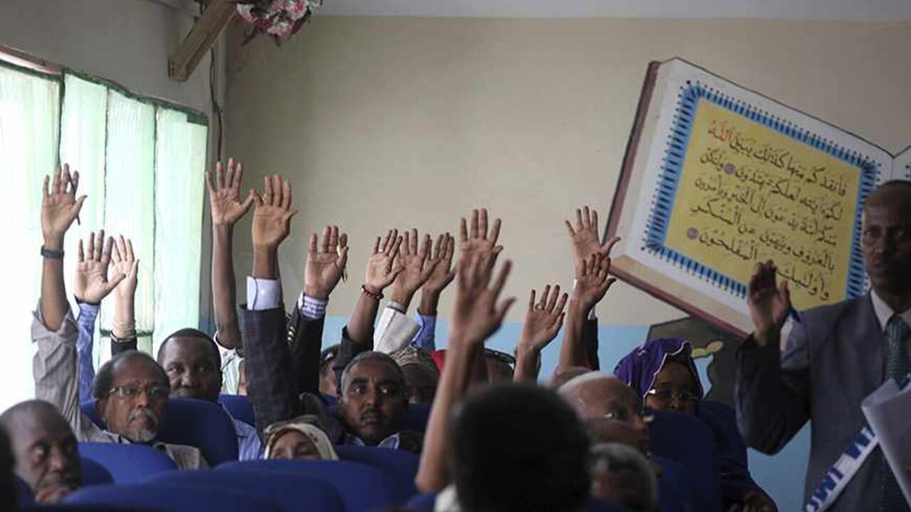 SOMALIA-POLITICS/ Members of the Somali parliament vote by a show of hands in Mogadishu December 2, 2013. Somalia's parliament voted on Monday to sack Prime Minister Abdi Farah Shirdon, the speaker of parliament said, after a row with the president that has paralysed the state and threatened a shaky recovery from war. The prime minister, who was appointed last year, fell out with President Hassan Sheikh Mohamud over what legislators said was a dispute over the composition of a new cabinet, prompting Monday's no confidence v