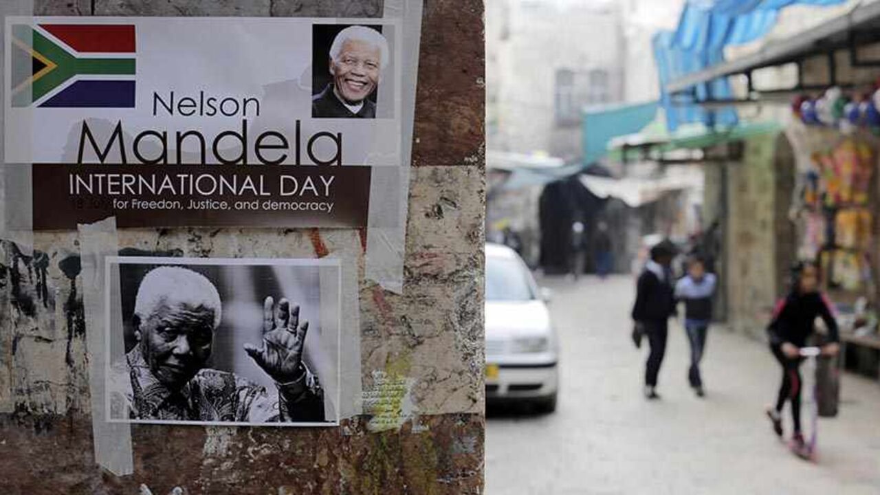 MANDELA/ Posters depicting former South African President Nelson Mandela are seen on a wall in Jerusalem's old city December 7, 2013. South African anti-apartheid hero Mandela died aged 95 at his Johannesburg home on December 5, 2013 after a prolonged lung infection. REUTERS/Ammar Awad (JERUSALEM - Tags: POLITICS OBITUARY) - RTX168F9