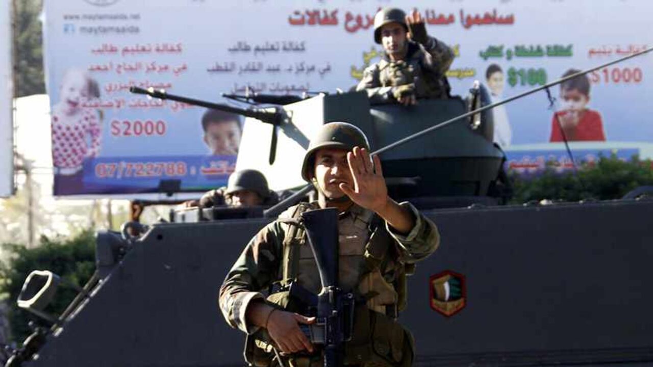 LEBANON-SIDON/ATTACKS A Lebanese army soldier gestures as they are deployed on their military vehicles on the streets of Sidon, southern Lebanon December 16, 2013. Gunmen attacked two army checkpoints outside the southern Lebanese city of Sidon on Sunday, killing a soldier and wounding three others, the army said. Four attackers were also killed in the clashes around the Mediterranean city, which was the scene of heavy fighting six months ago between the army and supporters of a Sunni Muslim cleric who backs rebels in neighbouri