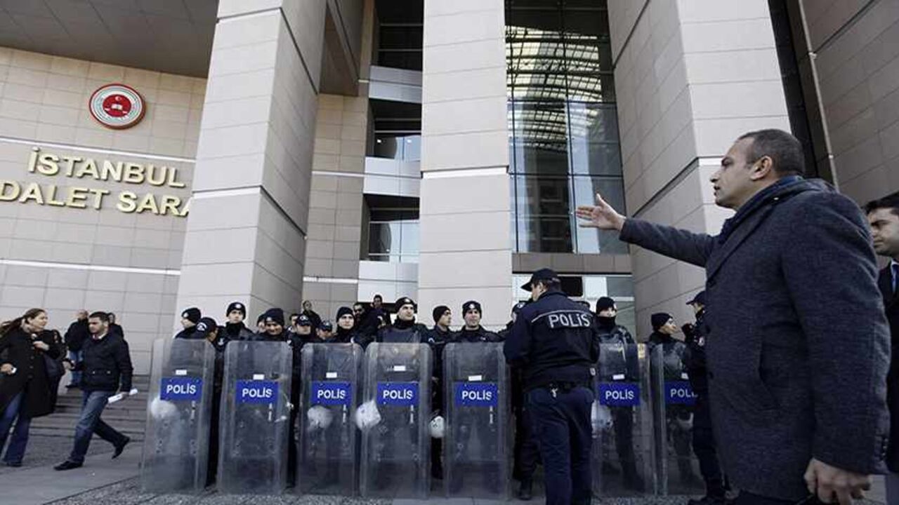TURKEY-CORRUPTION/ A plainclothes police officer reacts as riot police stand guard in front of the courthouse in Istanbul December 20, 2013. Turkish police arrested eight people in connection with allegations of official corruption and bribery, a newspaper said on Friday, in an investigation Prime Minister Tayyip Erdogan has called a "dirty operation" aimed at undermining his rule. REUTERS/Osman Orsal (TURKEY - Tags: POLITICS CRIME LAW) - RTX16PID
