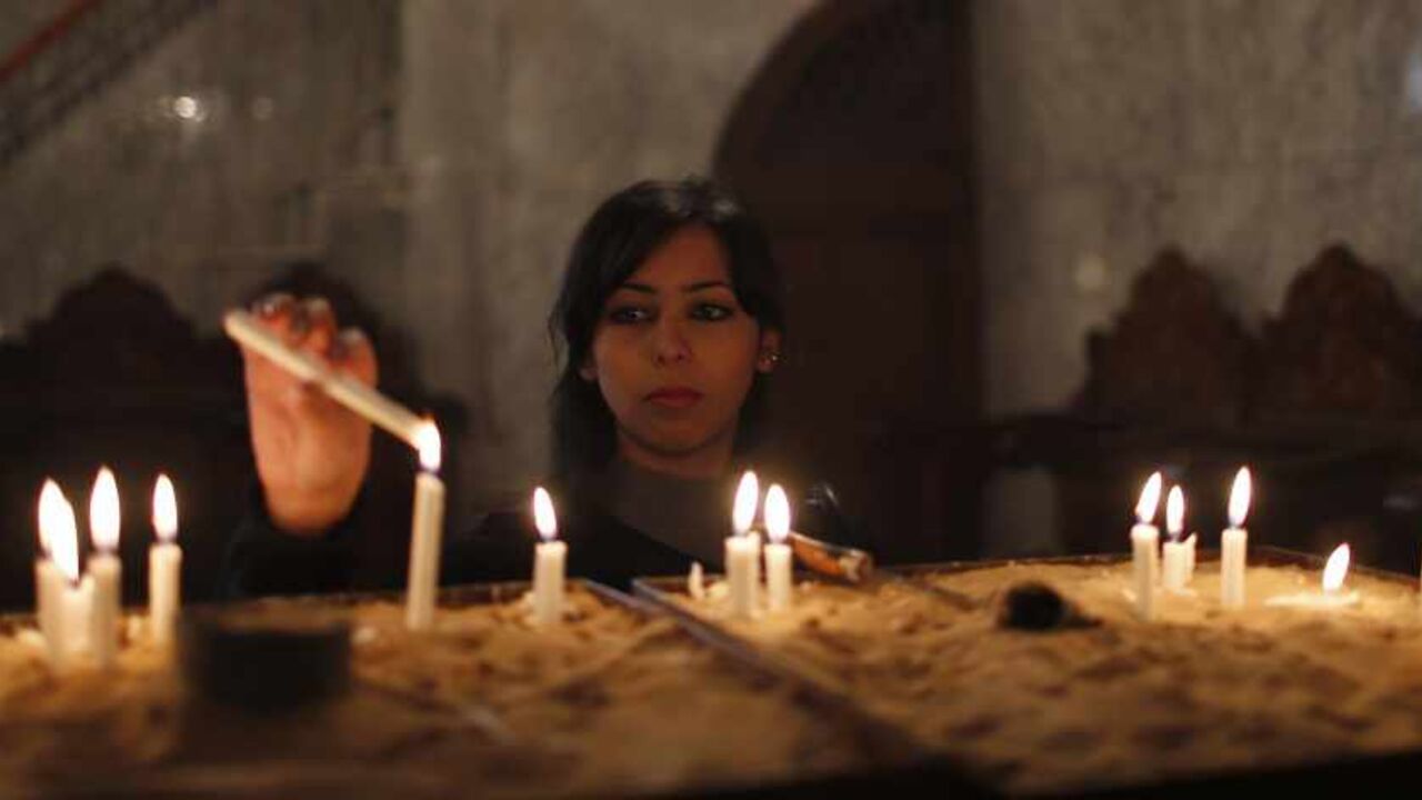 Palestinian Christian lights candles as she attend a service in Saint Porfirios church in Gaza City A Palestinian Christian lights candles as she attend a service in Saint Porfirios church in Gaza City December 22, 2013. REUTERS/Mohammed Salem (GAZA - Tags: SOCIETY RELIGION) - RTX16R7G