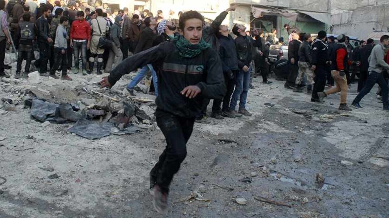 SYRIA-CRISIS/ALEPPO People run after what activists said was the return of government jet planes in Aleppo's al-Marja district December 23, 2013. More than 300 people have been killed in a week of air raids on the northern Syrian city of Aleppo and nearby towns by President Bashar al-Assad's forces, a monitoring group said on Monday. Many of the casualties, who included scores of women and children, were killed by so-called barrel bombs dropped from helicopters, the Syrian Observatory for Human Rights said. REUTERS/Saad AboB