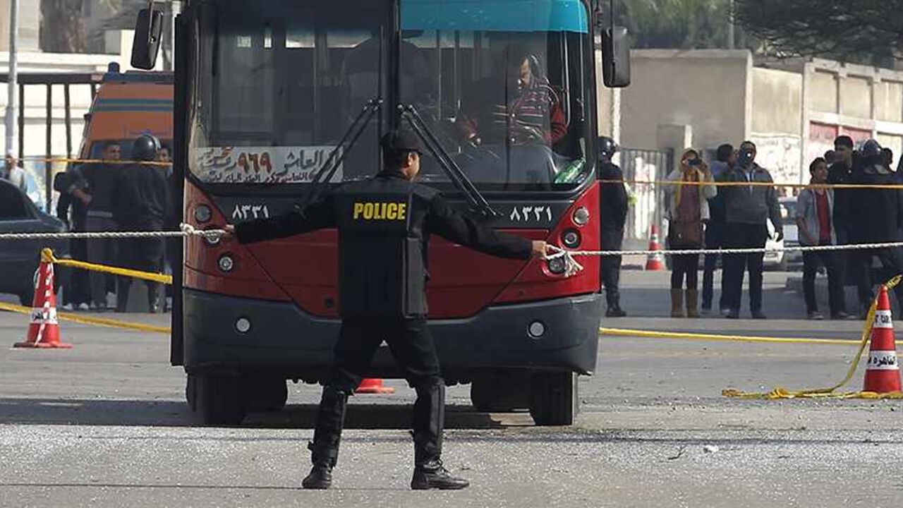 EGYPT-EXPLOSION/ A policeman stands guard at the scene of a bomb blast that damaged a bus near the Al-Azhar University campus in Cairo's Nasr City district December 26, 2013. The bomb blast hit the bus on Thursday, injuring four people, a spokesman for Egypt's interior ministry told Reuters, two days after a car bomb killed 16 in the Nile Delta. REUTERS/Amr Abdallah Dalsh (EGYPT - Tags: POLITICS CIVIL UNREST) - RTX16U8W