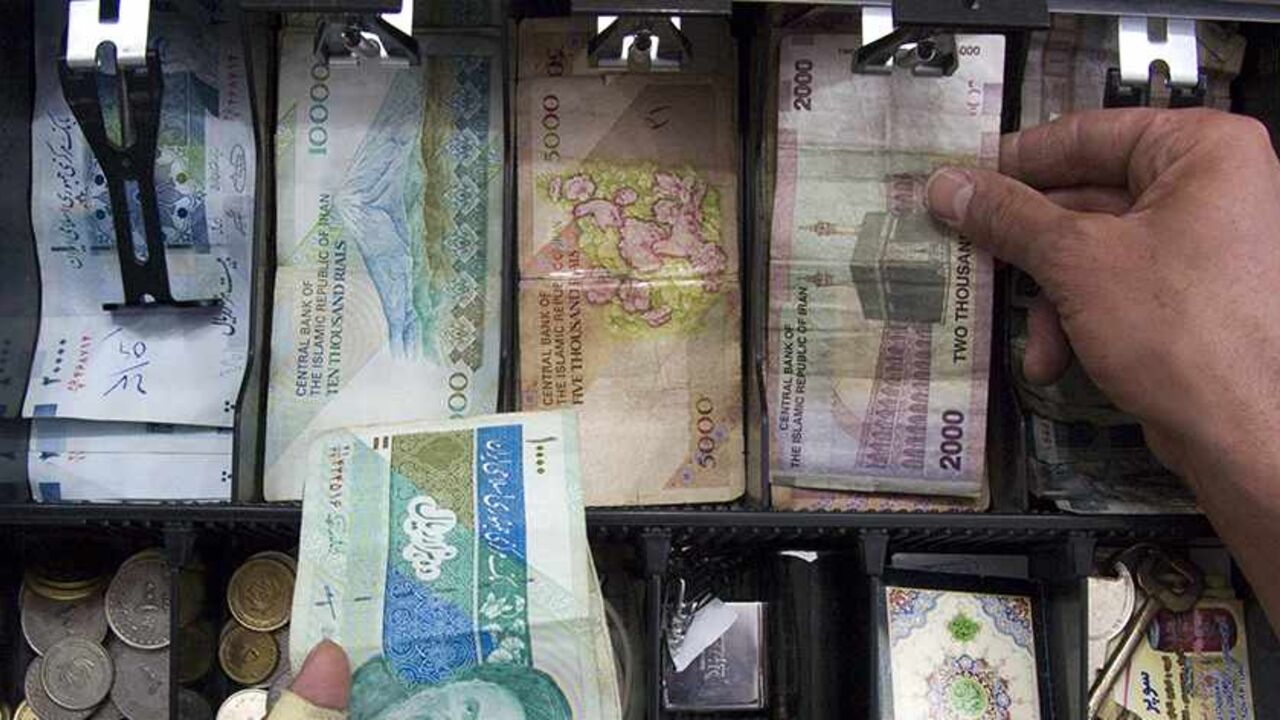 WITNESS-IRAN-SANCTIONS/BANK A storekeeper places money in the drawer of the cash register at his shop in Tehran May 4, 2008. With Western banks cutting ties with the Islamic Republic, it is becoming more and more difficult to transfer funds to the country of 70 million people. Tehran's increasing financial isolation is forcing some to bring in money by hand in thick wads of $100 bills on the plane from Dubai, the Gulf's financial centre, or elsewhere. REUTERS/Morteza Nikoubazl (IRAN) - RTX5GRN