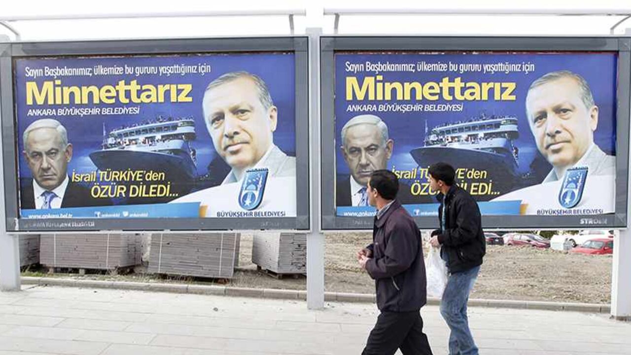 TURKEY-ISRAEL/ERDOGAN Pedestrians look at billboards with the pictures of Turkey's Prime Minister Tayyip Erdogan (R) and his Israeli counterpart Benjamin Netanyahu (L), in Ankara March 25, 2013. Turkey's Prime Minister Tayyip Erdogan said on Saturday an Israeli apology for the 2010 deaths of nine Turkish pro-Palestinian activists that was brokered by U.S. President Barack Obama met Turkey's conditions and signalled its growing regional clout. The billboard reads, "Israel apologized to Turkey. Dear Prime Minister (Erdogan), We ar