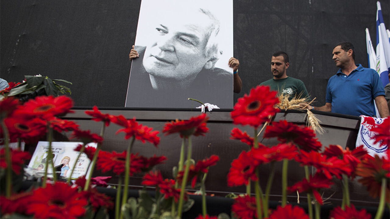 A placard depicting Israeli singer Einstein is placed atop his coffin ahead of a memorial ceremony in Tel Aviv A placard depicting Israeli singer Arik Einstein is placed atop his coffin ahead of a memorial ceremony before his funeral at Rabin square in Tel Aviv November 27, 2013. For many Israelis, nothing symbolised home more than singer Einstein, and on Wednesday a nation mourned the death of its king of cool. Einstein died of a ruptured aneurysm on Tuesday night at the age of 74. REUTERS/Nir Elias (ISRAEL - Tags: SOCIETY ENTERTAINMENT OBITUARY) - RTX15UZH