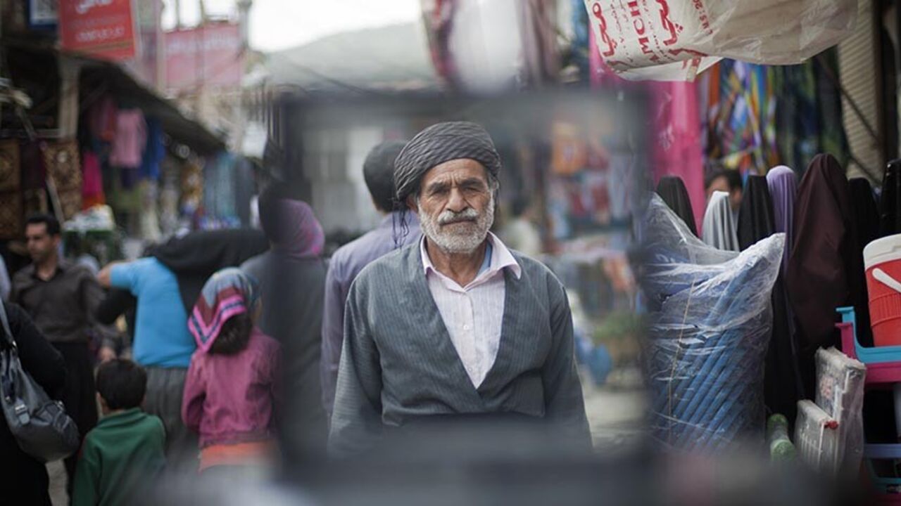 IRAN/ An Iranian Sunni Kurd walks at a bazaar while shopping in Marivan in Kurdistan province, 512 km (318 miles) west of Tehran, May 12, 2011. Iranian Shi'ite and Sunni Kurds live in harmony with each other in Marivan, although Sunni is the religion of the majority of the people. REUTERS/Morteza Nikoubazl (IRAN - Tags: SOCIETY RELIGION IMAGES OF THE DAY) - RTR2MC6O