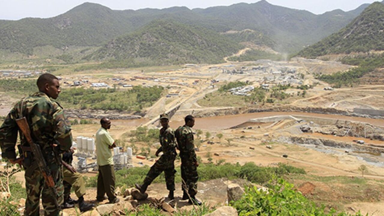 ETHIOPIA-EGYPT/NILE Security guards look at the construction of Ethiopia's Great Renaissance Dam in Guba Woreda, some 40 km (25 miles) from Ethiopia's border with Sudan, June 28, 2013. Egypt fears the $4.7 billion dam, that the Horn of Africa nation is building on the Nile, will reduce a water supply vital for its 84 million people, who mostly live in the Nile valley and delta. Picture taken June 28, 2013. REUTERS/Tiksa Negeri (ETHIOPIA - Tags: POLITICS SOCIETY ENERGY ENVIRONMENT) - RTX115K8