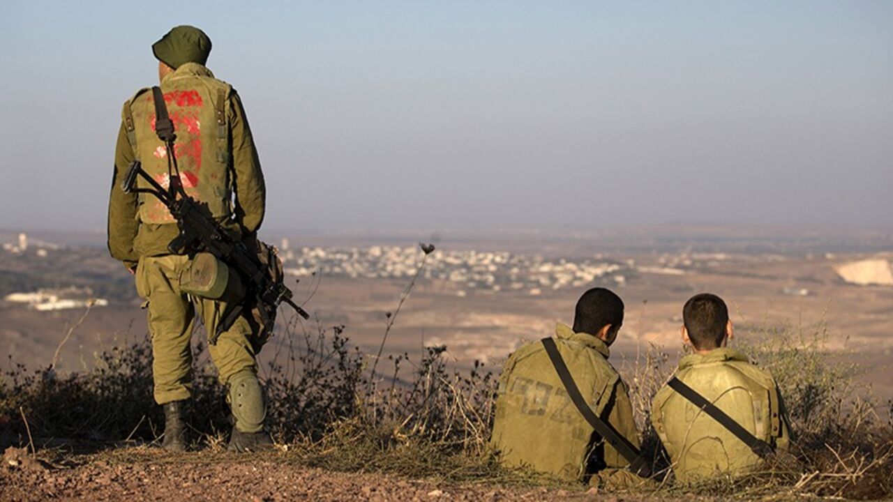 SYRIA-CRISIS/ISRAEL-DEFENCES Israeli soldiers look across the border to Syria in the Israeli-occupied Golan Heights August 30, 2013. Israel ordered a small-scale mobilisation of reservists on Wednesday and strengthened its missile defences as precautions against possible Syrian attack should Western powers carry out threatened strikes on Syria. REUTERS/Ronen Zvulun (MILITARY POLITICS) - RTX131QH