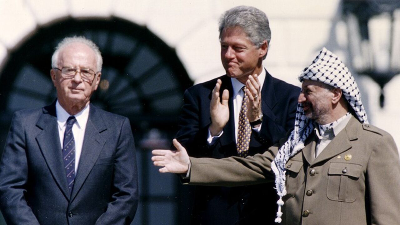 ISRAEL-PALESTINIANS/OSLO/ PLO Chairman Yasser Arafat (R) gestures to Israeli Prime Minister Yitzhak Rabin (L), as U.S. President Bill Clinton stands between them, following their handshake after the signing of the Israeli-PLO peace accord, at the White House in Washington September 13, 1993. REUTERS/Gary Hershorn (UNITED STATES - Tags: POLITICS) - RTX13K5G