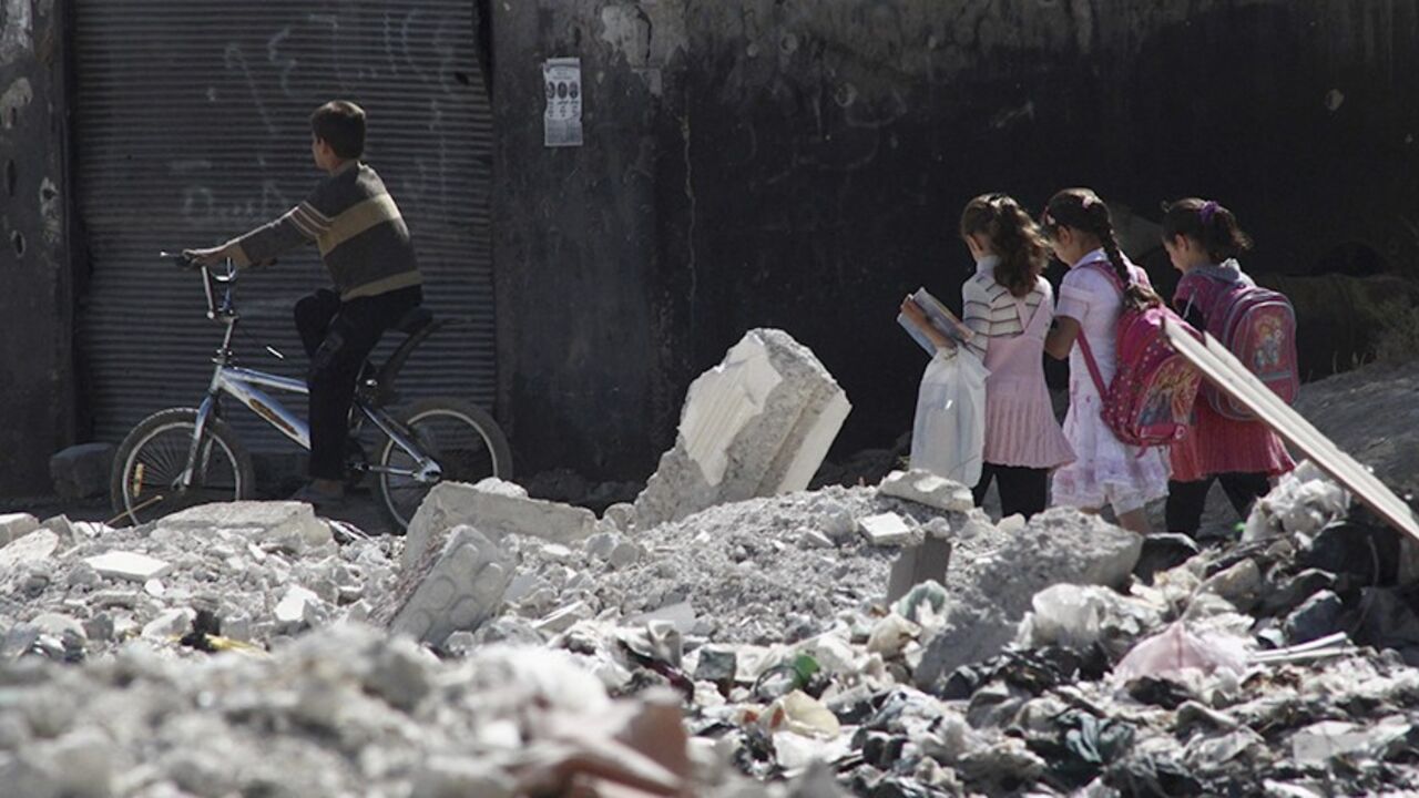 SYRIA-CRISIS Children go to school on a damaged street in Duma neighbourhood in Damascus October 12, 2013. REUTERS/Bassam Khabieh (SYRIA - Tags: POLITICS CIVIL UNREST CONFLICT TPX IMAGES OF THE DAY EDUCATION) - RTX148Z5