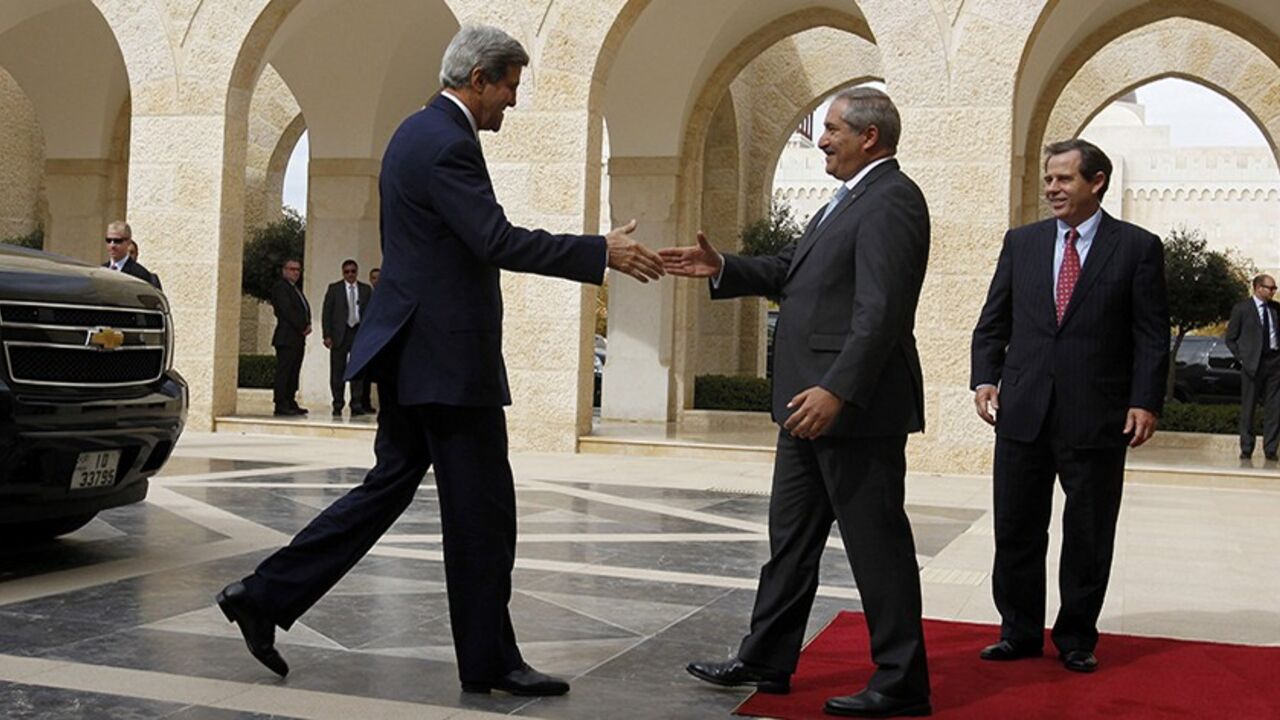 JORDAN/ Jordan's Foreign Minister Nasser Judeh (C) welcomes U.S. Secretary of State John Kerry upon his arrival at the Royal Palace in Amman, to meet with Jordan's King Abdullah, November 7, 2013. At right is U.S. Ambassador to Jordan Stuart Jones. REUTERS/Muhammad Hamed (JORDAN - Tags: POLITICS) - RTX153OT