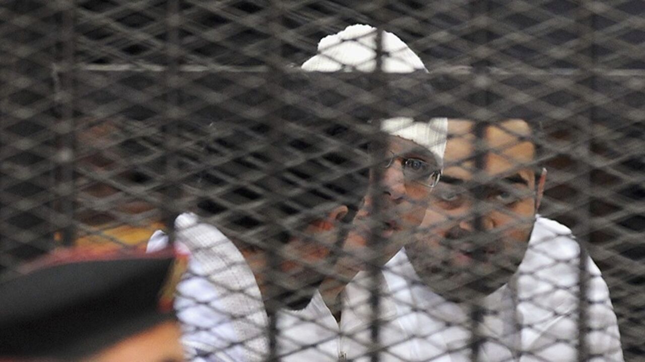EGYPT-PROTESTS/ Political activists Ahmed Maher, Ahmed Douma (L) and Mohamed Adel (R) of the 6 April movement look on from behind bars in Abdeen court in Cairo, December 22, 2013. Three leading Egyptian activists were sentenced to three years in prison each on Sunday in a case brought over their role in recent protests, escalating a crackdown on dissent by the army-backed government. Maher, Douma and Adel are symbols of the protest movement that ignited the historic 2011 uprising against President Hosni Mubarak. Each one