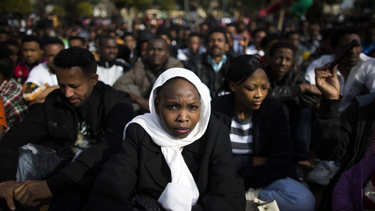 ISRAEL-MIGRANTS/ An African migrant sits with compatriots on the third day of protests against Israel's detention policy toward migrants it sees as illegal job-seekers, in Tel Aviv's Levinsky park January 7, 2014. REUTERS/Ronen Zvulun (ISRAEL - Tags: POLITICS CIVIL UNREST SOCIETY IMMIGRATION) - RTX17549
