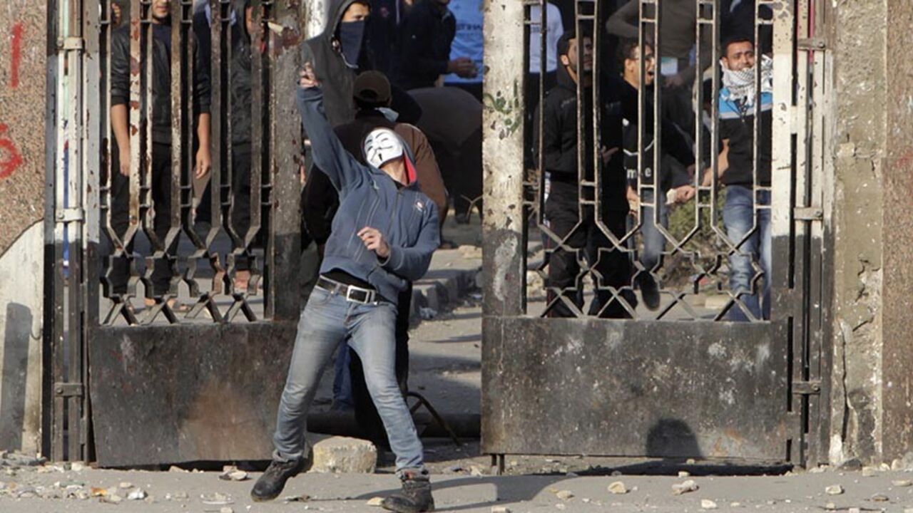 EGYPT-MURSI/ A student of Al-Azhar University, who is a supporter of the Muslim Brotherhood and deposed Egyptian President Mohamed Mursi, throws a stone during clashes with riot police and residents of the area at the university campus in Cairo's Nasr City district January 8, 2014. The trial of Mursi on charges of inciting murder of protesters was postponed on Wednesday until Feb. 1 after officials said that bad weather had prevented him being flown to court. REUTERS/Mohamed Abd El Ghany (EGYPT - Tags: POLITICS CIVIL U
