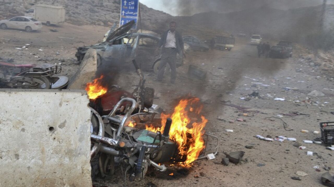 A man stands near a burning motorbike at the site of a car bomb attack at the Bab al-Hawa border crossing between Syria and Turkey, in Idlib A man stands near a burning motorbike at the site of a car bomb attack at the Bab al-Hawa border crossing between Syria and Turkey, in Idlib January 20, 2014. Two car bombs hit a rebel-held border post in the northwest Syrian province of Idlib on Monday, opposition activists and fighters said, killing at least 10 people and closing the frontier. The Bab al-Hawa crossing is held by a rebel alliance called the Islamic Front, which have been fighting with the al Qaeda-linked Islamic State in Iraq and the Levan