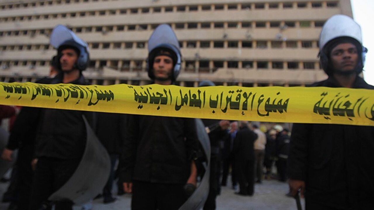 EGYPT-BLAST Riot police stand guard in front of the damaged Cairo Security Directorate building, which includes police and state security, after a bomb attack in downtown Cairo, January 24, 2014. A suicide bomber in a car blew himself up in the parking lot of a top security compound in central Cairo on Friday, killing at least four people in one of the most high-profile attacks on the state in months, security sources said. Yellow barrier tape reads, "Do not approach criminal lab". REUTERS/Amr Abdallah Dalsh (EGYPT -