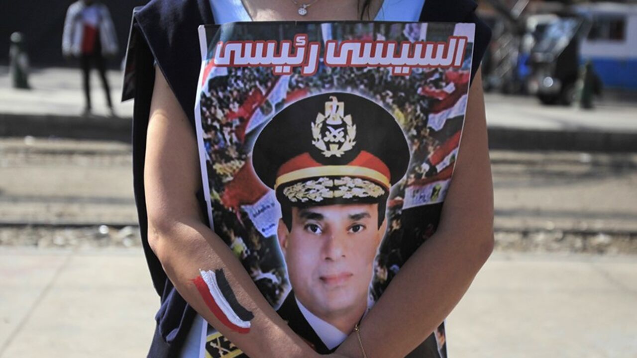 EGYPT-PROTESTS A supporter of Egypt's army chief General Abdel Fatah al-Sisi hugs his poster during celebrations of the third anniversary of Egypt's uprising, in front of El-Thadiya presidential palace in Cairo January 25, 2014. Egyptian police fired live rounds in the air to disperse about 1,000 anti-government protesters in central Cairo on Saturday, a Reuters witness said, amid fears of violence on the anniversary of the 2011 revolt that ousted autocrat Hosni Mubarak. The poster reads "al-Sisi is my president." REUTERS