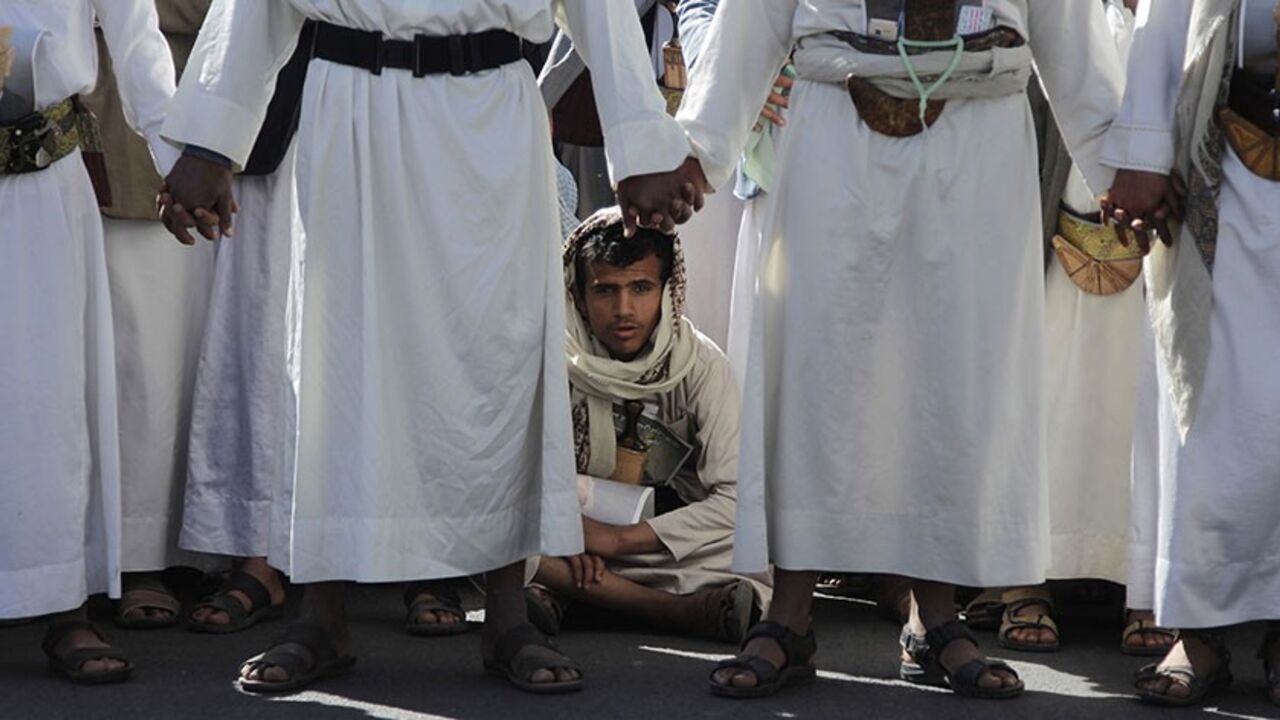 A mourner sits during the funeral of assassinated Shi'ite leader Ahmad Sharafeddin in Sanaa January 27, 2014. Unknown assailants shot and killed Sharafeddin on January 21 while he was on his way to attend reconciliation talks in the Yemeni capital, officials at the talks said. REUTERS/Khaled Abdullah (YEMEN - Tags: POLITICS CIVIL UNREST RELIGION OBITUARY) - RTX17WSB