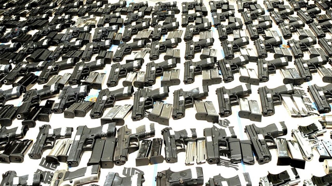 TAIWAN/ Police officers display seized firearms and ammunition for the media after a smuggling bust in Kaohsiung September 26, 2009. A haul of 181 guns and 22,685 rounds of ammunition were displayed for the media on Saturday as six suspects were arrested in what may be the largest arms smuggling bust ever in Taiwan, the Criminal Investigation Bureau (CIB) said. CIB officials said the seized weapons are standard models manufactured in Italy, Germany, Israel and the U.S. Picture taken September 26, 2009. REUTERS/St