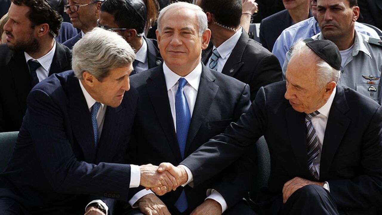 ISRAEL/ Israeli President Shimon Peres (R) shakes hands with U.S. Secretary of State John Kerry (L) as Prime Minister Benjamin Netanyahu sits in between them during a ceremony marking Israel's annual day of Holocaust remembrance, at Yad Vashem in Jerusalem April 8, 2013. Israel on Monday commemorates the six million Jews killed by the Nazis in the Holocaust during World War Two.
REUTERS/Gali Tibbon/Pool (JERUSALEM - Tags: POLITICS ANNIVERSARY CONFLICT) - RTXYDCO