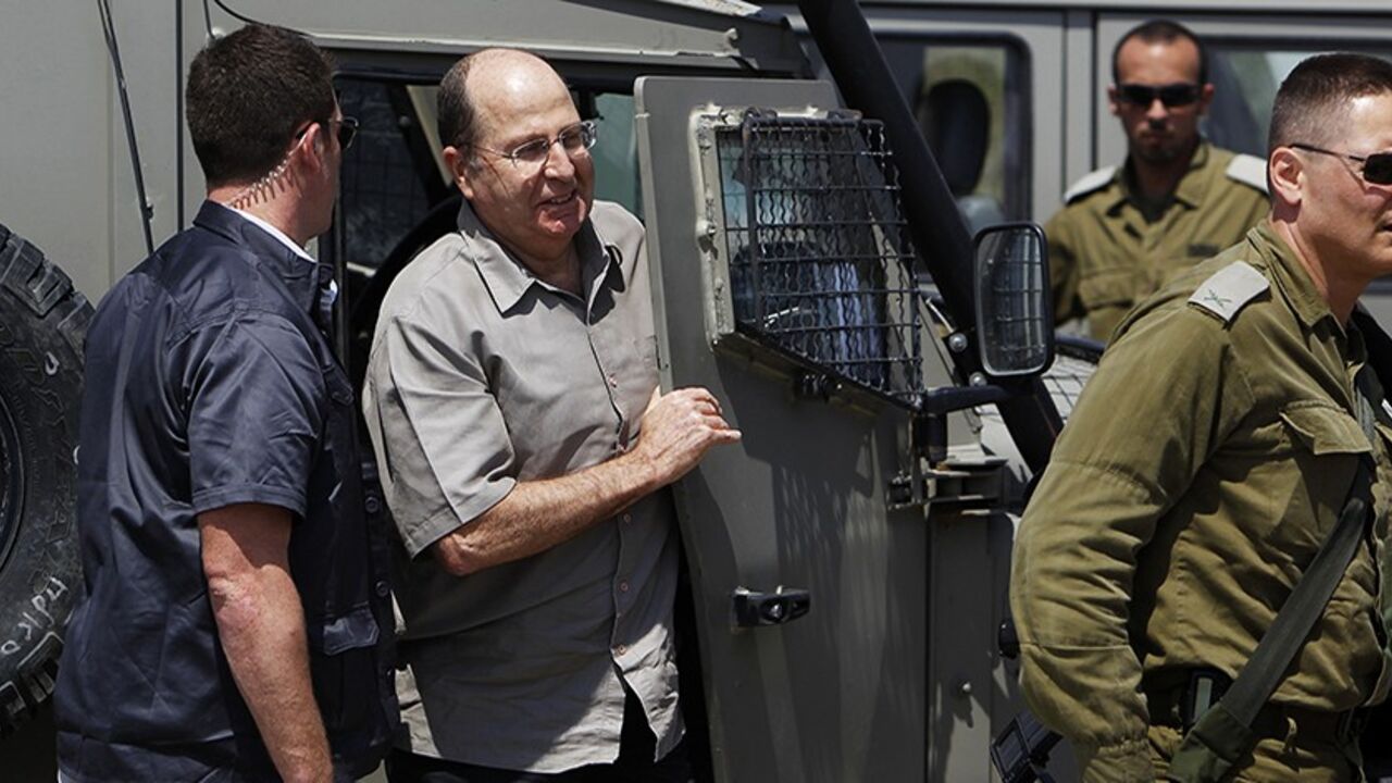 SYRIA-CRISIS/ Israeli Defense Minister Moshe Yaalon (2nd L) gets out of a military jeep during a visit to an army base near Kibbutz Kissufim outside the central Gaza Strip May 7, 2013. Israel played down weekend air strikes close to Damascus reported to have killed dozens of Syrian soldiers, saying they were not aimed at influencing its neighbour's civil war but only at stopping Iranian missiles reaching Lebanese Hezbollah militants. REUTERS/Amir Cohen (ISRAEL - Tags: MILITARY POLITICS) - RTXZDJS