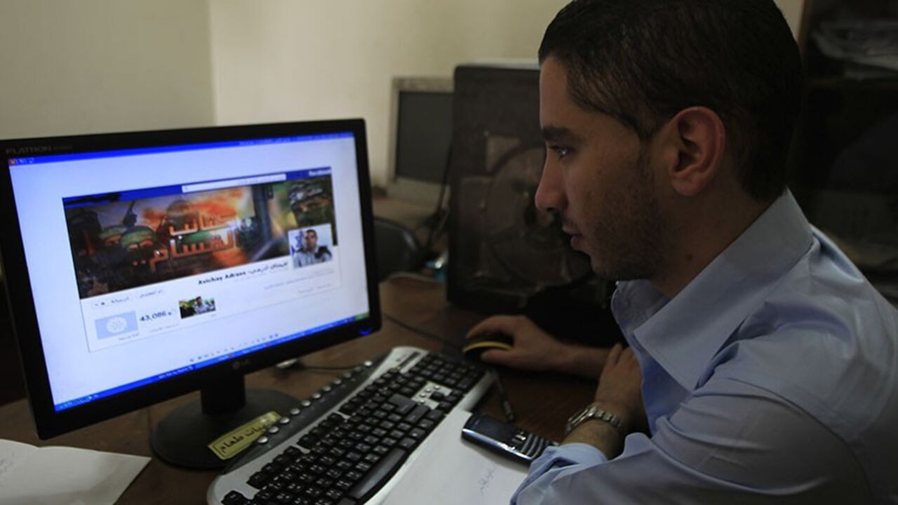 Nic6207037 A Palestinian man looks at the Facebook page of Avichay Adraee, the spokesman of the Israeli Army to the Arabic media, after hackers replaced his cover photo with that of the Ezzedine al-Qassam Brigade during the "#Op_Israel" campaign launched by the activist group Anonymous, in Gaza City on April 7, 2013. The hackers reportedly hit several Israeli websites including that of the premier's office, the defence ministry, the education ministry and the Central Bureau of Statistics, among others, but all appeare
