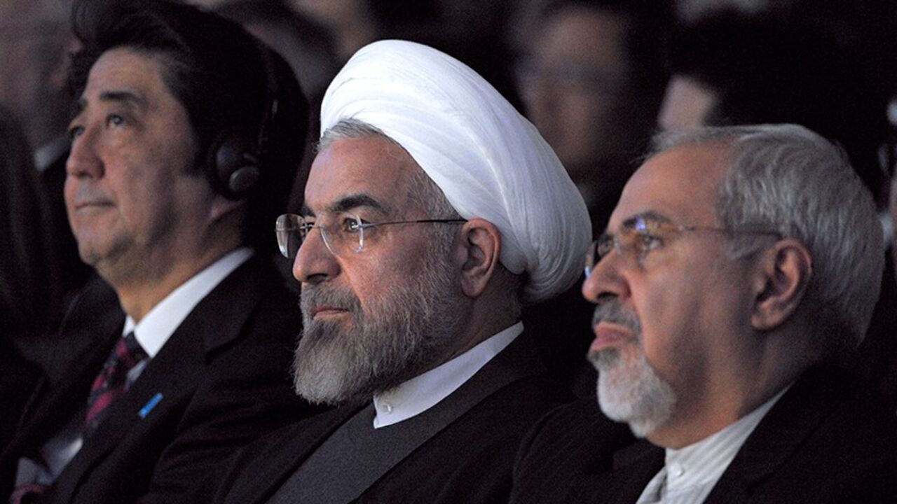 Par7771567 Iranian President Hassan Rouhani (C) sits next to Japanese Prime Minister Shinzo Abe (L) and Iranian Foreign Minister Mohammad Javad Zarif (R) during the World Economic Forum in Davos on January 22, 2014. Iran's President Hassan Rouhani takes centre stage at the Davos World Economic Forum Thursday, as he seeks to drum up investment for his sanctions-hit economy amid thawing relations with the West. AFP PHOTO ERIC PIERMONT (Photo credit should read ERIC PIERMONT/AFP/Getty Images)