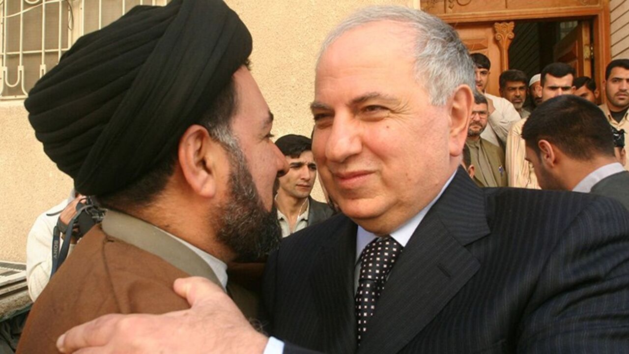IRAQ ELECTIONS Iraqi National Congress candidate Ahmed Chalabi embraces a supporter while campaigning for next week's parliamentary elections in Najaf December 11, 2005. Iraq will close its borders and impose curfews across the country as it ramps up security for Thursday's election, the Interior Ministry said on Sunday. REUTERS/Ali Abu Shish - RTR1AR02