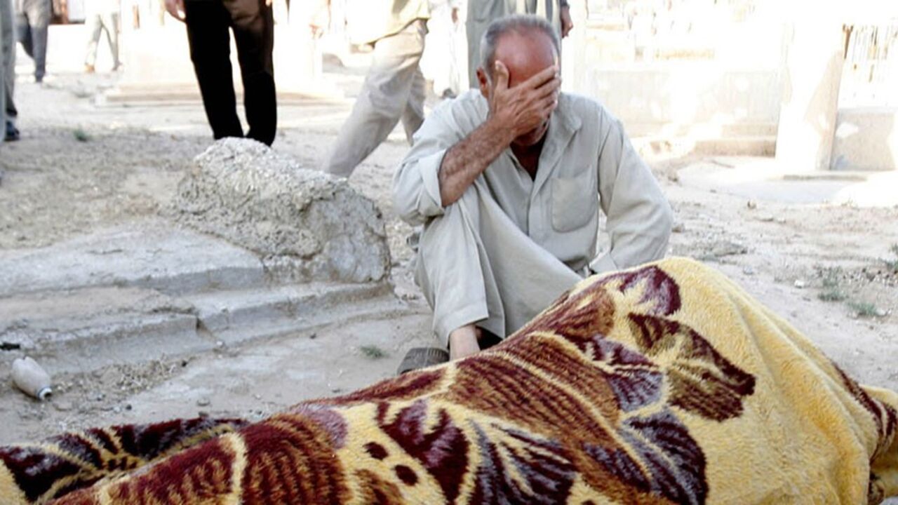 IRAQ A man mourns near the body of his brother, wrapped in a blanket, who was among those killed during Sunday night's suicide bomb attack at a popular coffee shop in the town of Tuz Khurmatu, 170 km (106 miles) north of Baghdad, July 17, 2006. The attack killed 21 people, mostly elderly men. REUTERS/Slahaldeen Rasheed (IRAQ) - RTR1FKIO