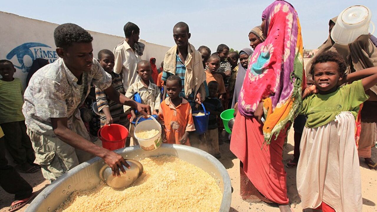 Displaced Somalis queue for food at a centre run by a Turkish aid agency in the Howlwadaag district of southern Mogadishu, January 22, 2012. From Turkey to Brazil, India to Saudi Arabia, a growing number of non-Western donors are bringing fresh funds, a different mindset and their own experience of managing natural disasters to the global humanitarian aid scene.  Picture taken January 22, 2012.  To match Feature DISASTERS-NEWDONORS/       REUTERS/Feisal Omar (SOMALIA - Tags: SOCIETY POVERTY) - RTR2WVRE