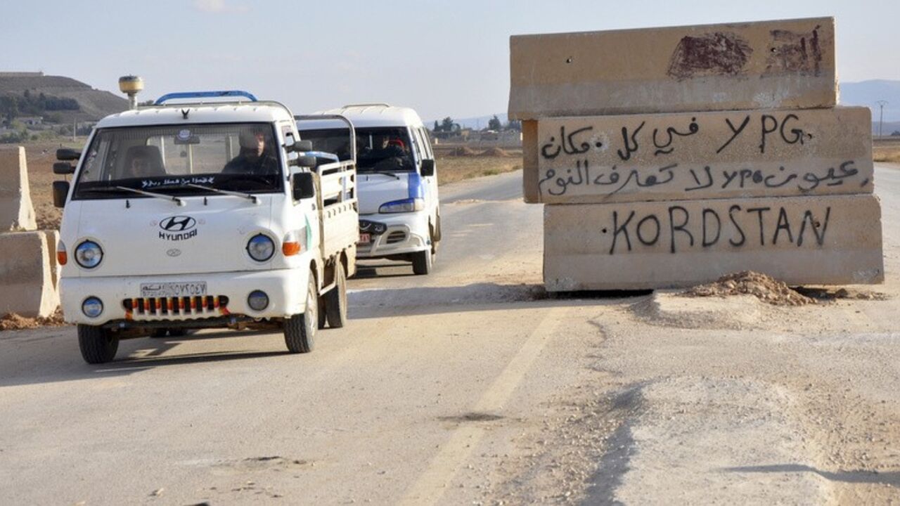 Vehicles pass a Kurdish People's Protection Units (YPG) checkpoint in Tell Tamer town in Hasaka Vehicles pass a Kurdish People's Protection Units (YPG) checkpoint in Tell Tamer town in Hasaka, November 30, 2013. The text on the barrier reads in Arabic "YPG are everywhere, YPG don't sleep". Picture taken November 30, 2013. REUTERS/Rodi Said (SYRIA - Tags: POLITICS CIVIL UNREST CONFLICT) - RTX15ZU5
