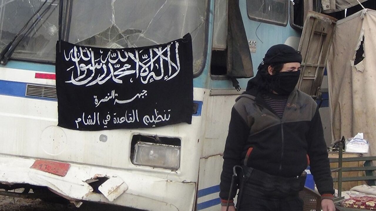 SYRIA-CRISIS/ A member of Islamist Syrian rebel group Jabhat al-Nusra mans a checkpoint on the border crossing between Syria and Jordan, which they claim to have taken control of, in Daraa December 26, 2013. Flag reads, "There is no God but Allah, and Muhammad is his prophet. Al-Nusra front, al-Qaeda in the Levant". Picture taken December 26, 2013. REUTERS/Ammar Khassawneh (SYRIA - Tags: POLITICS CIVIL UNREST CONFLICT) - RTX16VW7