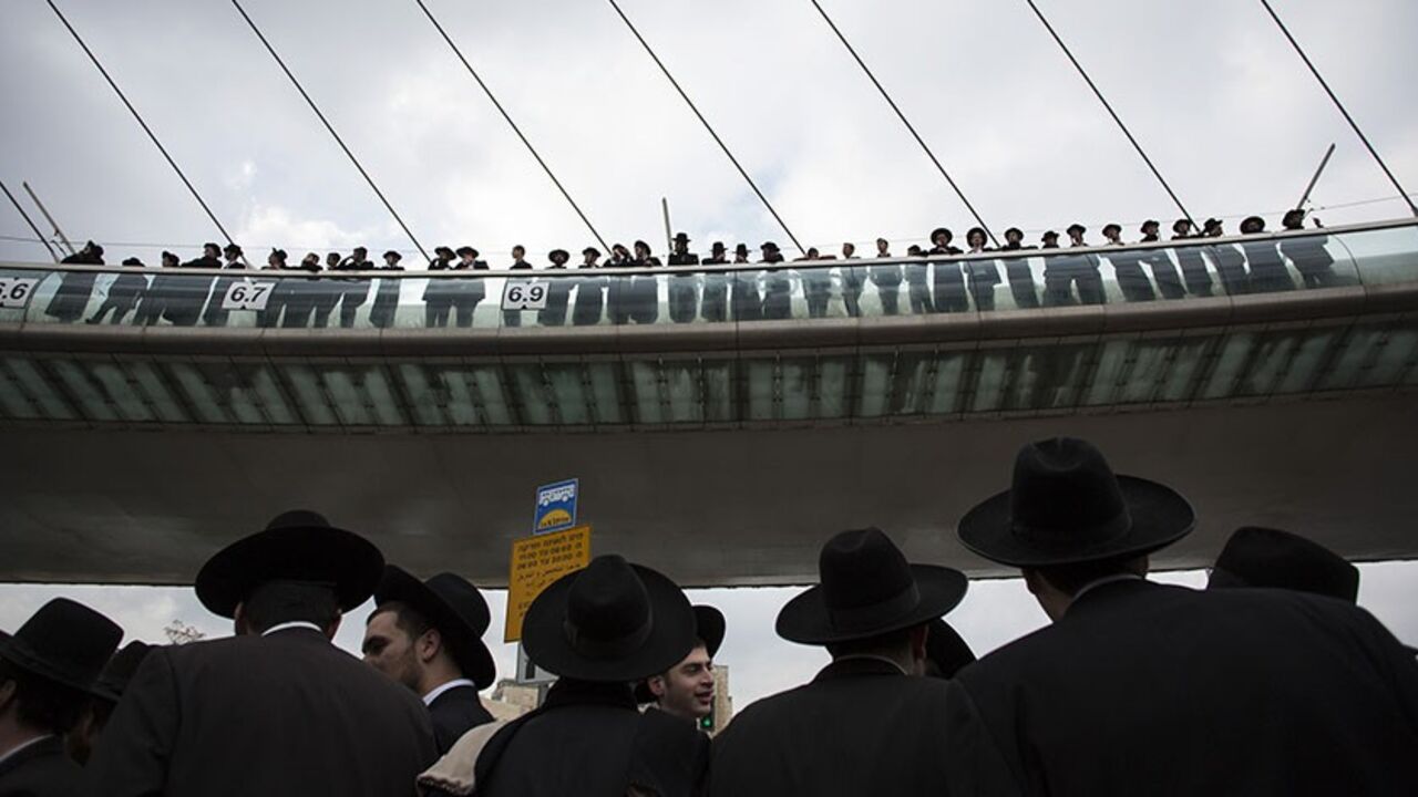 ISRAEL-CONSCRIPTION/ Ultra-Orthodox Jewish protesters, some standing on a bridge, take part a demonstration in Jerusalem February 6, 2014. Hundreds of ultra-Orthodox Jews in Israel blocked highways and clashed with police on Thursday in protest at a government decision to cut funds to seminary students who avoid military service. REUTERS/Baz Ratner (JERUSALEM - Tags: POLITICS RELIGION CIVIL UNREST) - RTX18AZA