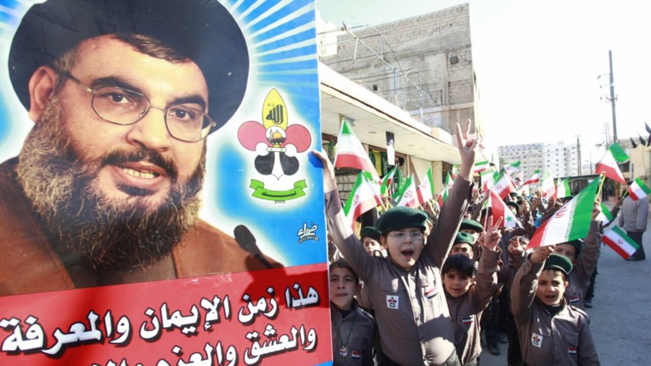 SYRIA-CRISIS/ Syrian children chant anti- Free Syrian Army slogans as their hold posters of Hezbollah leader Sayyed Hassan Nasrallah and Iranian flags at the Sayeda Zainab area in Damascus, February 10, 2014. Picture taken February 10, 2014. REUTERS/Alaa Al-Marjani (SYRIA - Tags: CIVIL UNREST POLITICS CONFLICT) - RTX18VH0