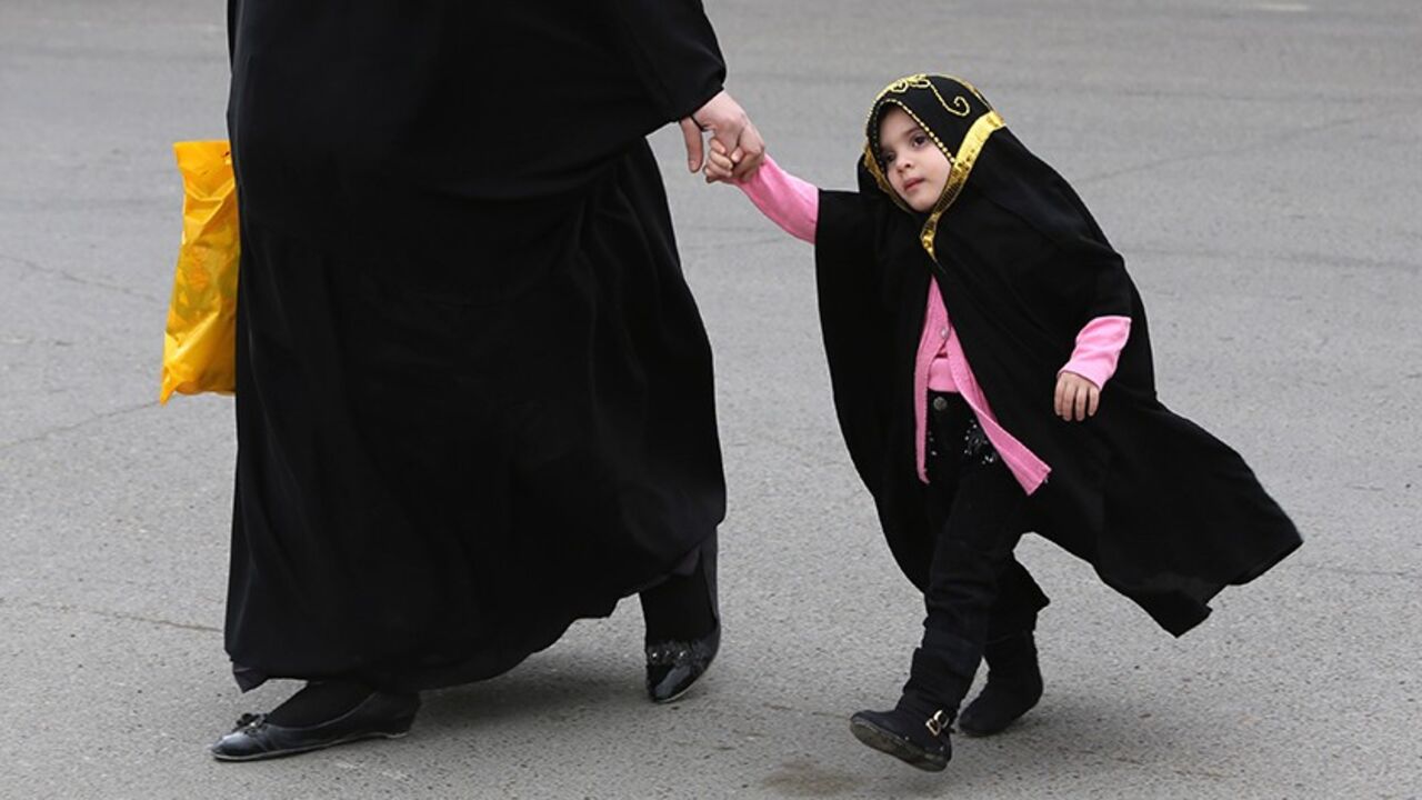 Nic6308647 TO GO WITH AFP STORY BY AMMAR KARIM
An Iraqi woman walks with her fully veiled daughter in Baghdad on March 18, 2014. A bill before Iraq's parliament that opponents say legalises child marriage and marital rape has sparked controversy ahead of elections as secular activists face off against the draft law's backers. The bill, the Jaafari Personal Status Law, sets out rules to do with inheritance, marriage and divorce. Supporters of the draft, named after a Shiite Muslim school of jurisprudence, say it simply
