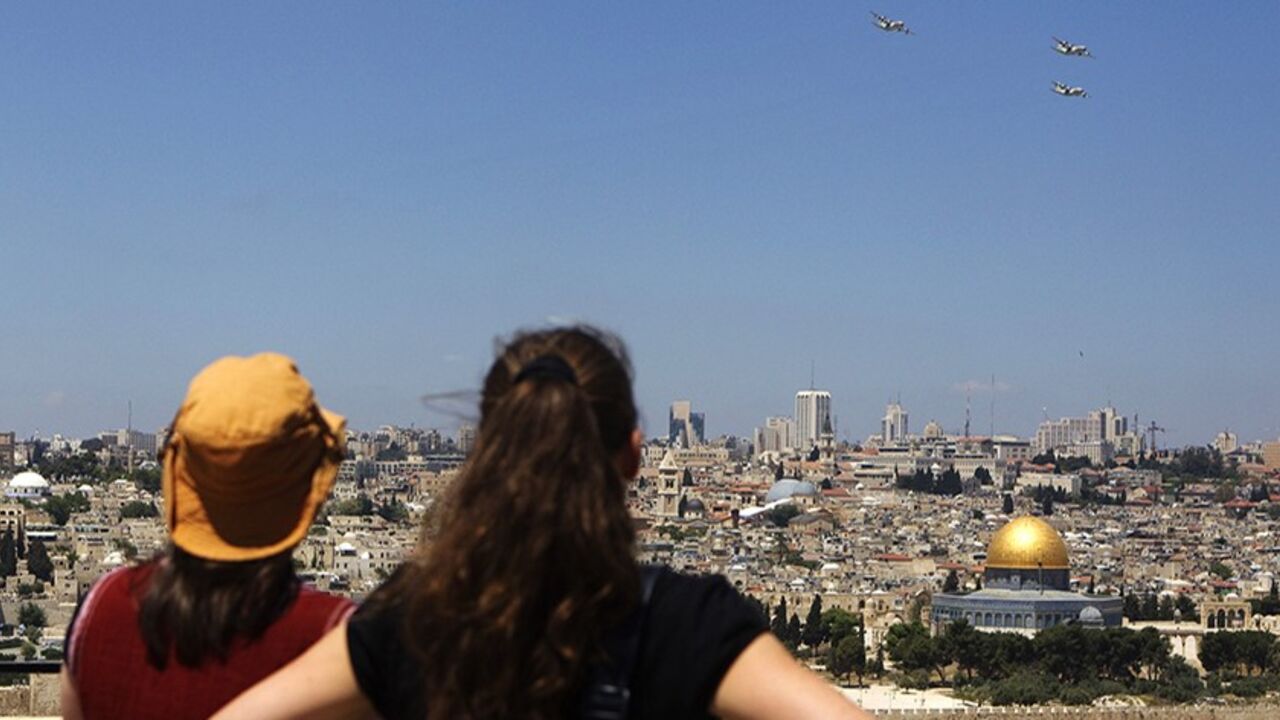 ISRAEL/ People watch planes from the Israeli Air Force fly over Jerusalem during celebrations marking Israel's 63rd Independence Day in Jerusalem May 10, 2011. REUTERS/Darren Whiteside (JERUSALEM - Tags: ANNIVERSARY MILITARY TRANSPORT) - RTR2M7SX