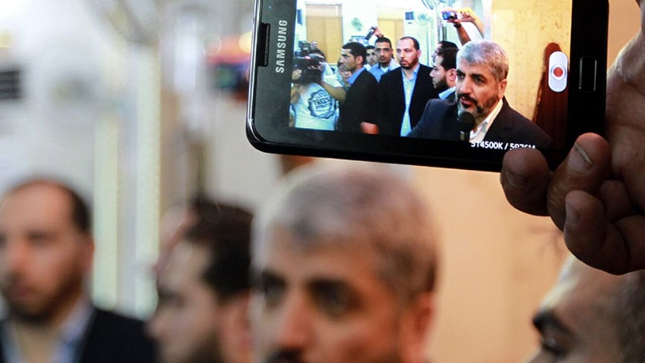 JORDAN/ A man uses a mobile phone to record Hamas leader Khaled Meshaal (C) while he speaks during the funeral of Hamas member Kamal Husni Ghanaja in Amman June 29, 2012. Hamas said on Thursday that one of its members, Ghanaja, had been killed in his home in Damascus. REUTERS/Muhammad Hamed (JORDAN - Tags: POLITICS) - RTR34D20