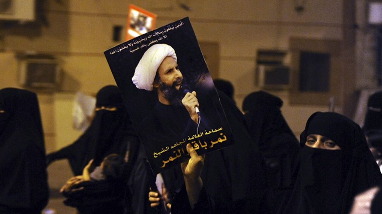 SAUDI-ARREST/ A protester holds up a picture of Sheikh Nimr al-Nimr during a rally at the coastal town of Qatif, against Sheikh Nimr's arrest July 8, 2012. Sheikh Nimr, a prominent Shi'ite Muslim cleric who was wanted by the police, was detained in Saudi Arabia's Eastern Province on Sunday over calls for more rights for the minority Muslim sect in the Sunni monarchy, his brother and an activist said. REUTERS/Stringer (SAUDI ARABIA - Tags: CIVIL UNREST RELIGION POLITICS) - RTR34QU8