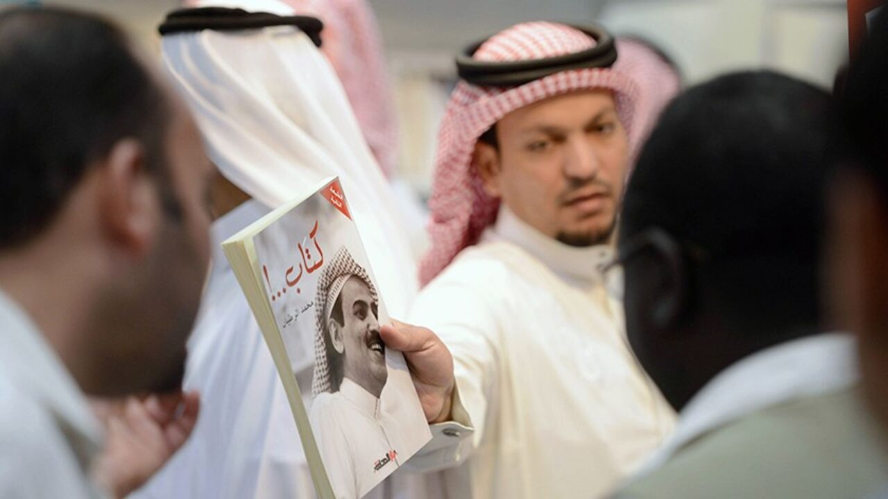RIYADH/ A man shows a book by Saudi writer and poet Mohamed Al-Rotayyan during the Riyadh Book Fair at the International Exhibition Center in Riyadh March 9, 2013. Picture taken March 9, 2013. REUTERS/Faisal Al Nassar (SAUDI ARABIA - Tags: EDUCATION SOCIETY) - RTR3ET2Q