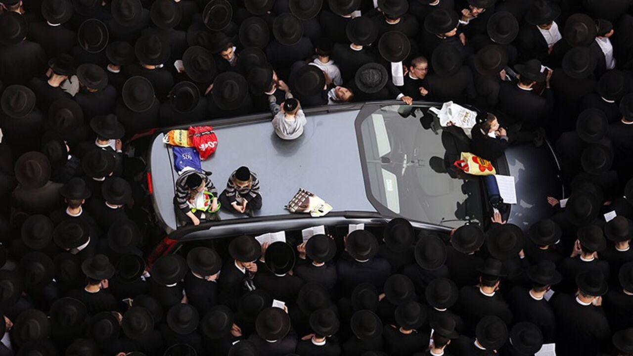 ISRAEL-CONSCRIPTION/ Ultra-Orthodox Jewish men stand around a car during a mass prayer in Jerusalem March 2, 2014. Hundreds of thousands of ultra-Orthodox Jews held a mass prayer in Jerusalem on Sunday in protest at a bill that would cut their community's military exemptions and end a tradition upheld since Israel's foundation. REUTERS/Darren Whiteside (JERUSALEM - Tags: POLITICS RELIGION MILITARY TPX IMAGES OF THE DAY) - RTR3FWQW