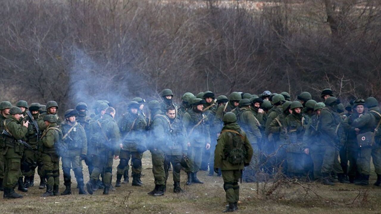 UKRAINE-CRISIS/ Armed men, believed to be Russian soldiers, assemble near an Ukrainian military base in Perevalnoe March 5, 2014. Ukraine's government said on Wednesday "Russian aggression" in Crimea was hitting the country's economy hard but signalled growing confidence that it will secure international loans and avoid bankruptcy. REUTERS/Thomas Peter (UKRAINE - Tags: POLITICS MILITARY) - RTR3G2SD
