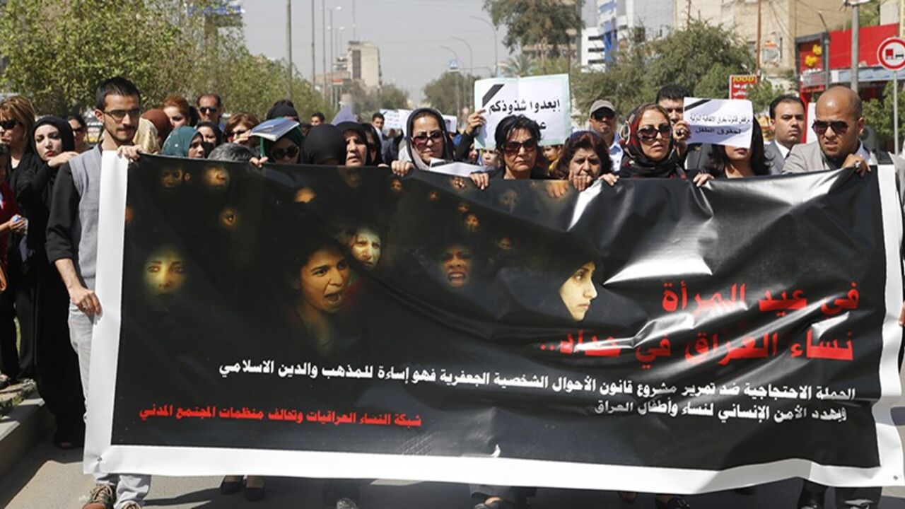 IRAQ/ Iraqi Protesters hold a banner during a demonstration against the draft of the "Al-Jafaari" Personal Status Law during International Women's Day in Baghdad March 8, 2014. Protesters say the law, which involves the use of Shi'ite Jafaari law with regards to divorce, marriage and inheritance, will restrict their personal rights, according to local media. On March 8 activists around the globe celebrate International Women's Day, which dates back to the beginning of the 20th Century and has been observed by the