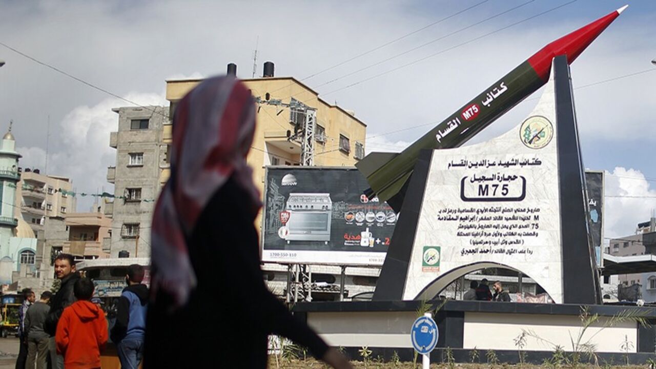 ISRAEL-PALESTINIANS/ A Palestinian girl walks past a monument of a homemade M75 rocket in the middle of a square in Gaza City March 10, 2014. Hamas fired M75 rockets at Tel Aviv and Jerusalem in the 2012 eight-day fighting with Israel. REUTERS/Mohammed Salem (GAZA - Tags: POLITICS CIVIL UNREST) - RTR3GEHZ