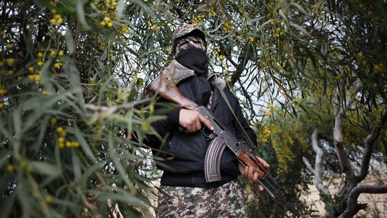 An Islamic Jihad militant stands guard near a military base that was targeted in an Israeli air strike in Khan Younis in the southern Gaza Strip March 13, 2014. Palestinian militants in the Gaza Strip fired rockets at Israeli cities on Thursday in the second day of a cross-border flare-up that has drawn Israeli warnings of a tough military response. The Israeli military carried out 29 air strikes and fired tank shells at militant targets in the Gaza Strip on Wednesday after the Islamic Jihad group launched 