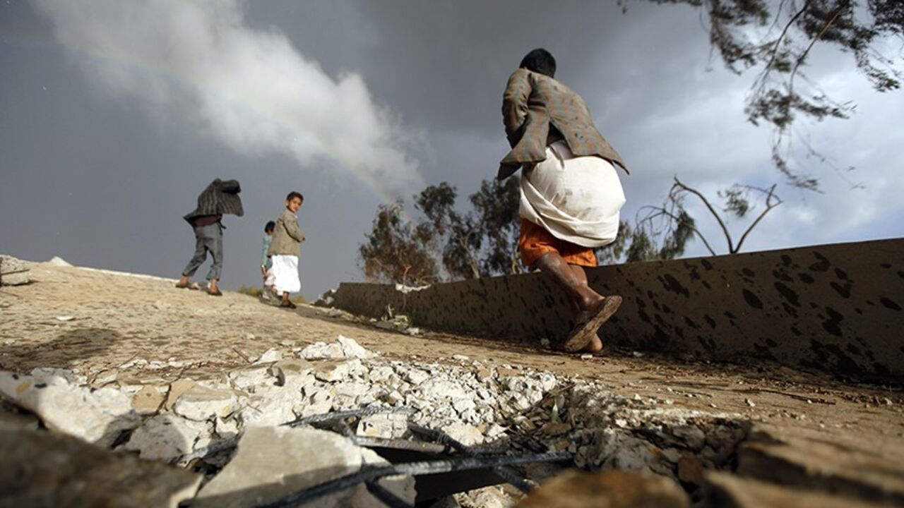 YEMEN/ Boys walk on the ruins of their school which was bombed by Shi'ite militants of the Shi'ite al-Houthi group during recent conflicts against local tribes in the Hamdan area west of the Yemeni capital Sanaa March 23, 2014. REUTERS/Mohamed al-Sayaghi (YEMEN - Tags: POLITICS SOCIETY CIVIL UNREST) - RTR3I8RJ