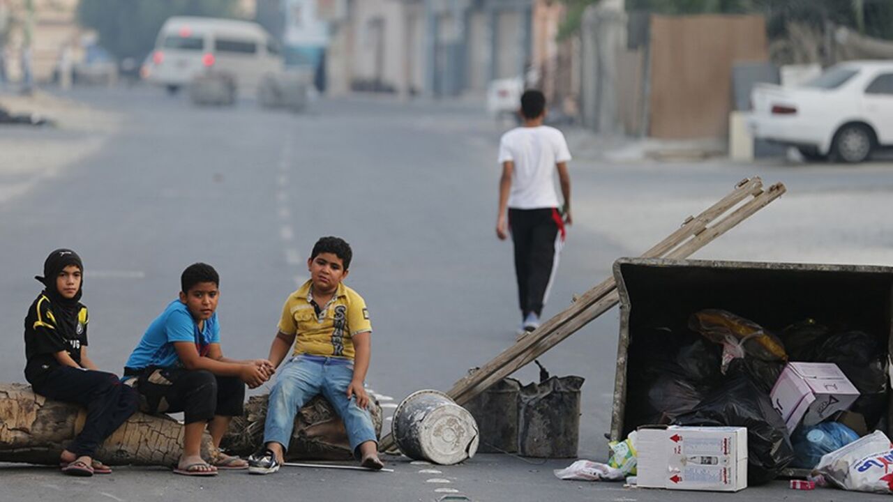 BAHRAIN-PROTEST/ Children sit on a roadblock set up by protesters to prevent riot police from entering the village of Shakhoora, west of Manama, August 14, 2013. Bahraini police fired tear gas and birdshot at demonstrators on Wednesday, witnesses said, as protests called for by activists to press demands for democratic change in the U.S.-allied Gulf kingdom turned violent. REUTERS/Hamad I Mohammed (BAHRAIN - Tags: POLITICS CIVIL UNREST) - RTX12LBN
