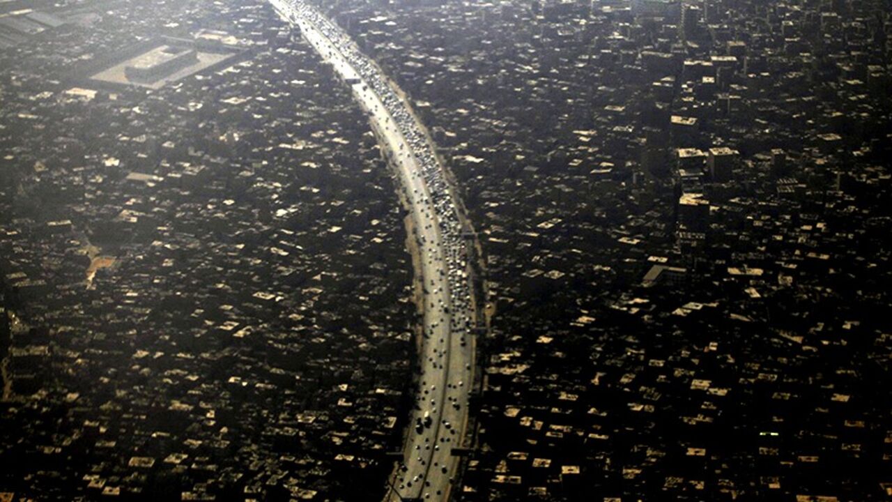 EGYPT/ An aerial view of Cairo's traffic and houses is pictured through the window of an airplane September 11, 2013. Egypt's population has reached 85 million with the Cairo governorate coming in with the highest number at 8.9 million people, according to the Central Agency for Public Mobilization and Statistics (CAPMAS). REUTERS/Amr Abdallah Dalsh (EGYPT - Tags: CITYSCAPE) - RTX13HWO